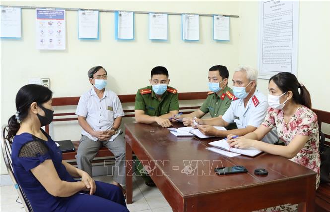 Trong ảnh: Đối tượng N.T.Tuyết (bên trái), sinh năm 1965, trú tại phường Yên Bình, thành phố Tam Điệp, tỉnh Ninh Bình tại buổi làm việc với cơ quan chức năng để làm rõ về hành vi cung cấp, chia sẻ thông tin bịa đặt trên mạng xã hội rằng “chân ngôn” Pháp Luân Công chữa khỏi bệnh COVID-19. Cơ quan chức năng đã ra quyết định xử phạt vi phạm hành chính đối tượng 10 triệu đồng và yêu cầu gỡ bỏ bài viết, cam kết không tái phạm. Ảnh: Đức Phương - TTXVN
