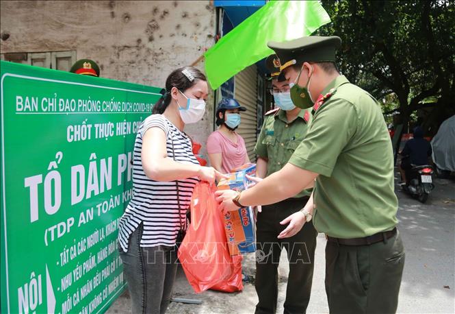 Trong ảnh: Đại diện Đoàn Thanh niên Công an Hà Nội trao tặng các phần quà cho người dân gặp khó khăn bởi dịch COVID-19. Ảnh: TTXVN phát