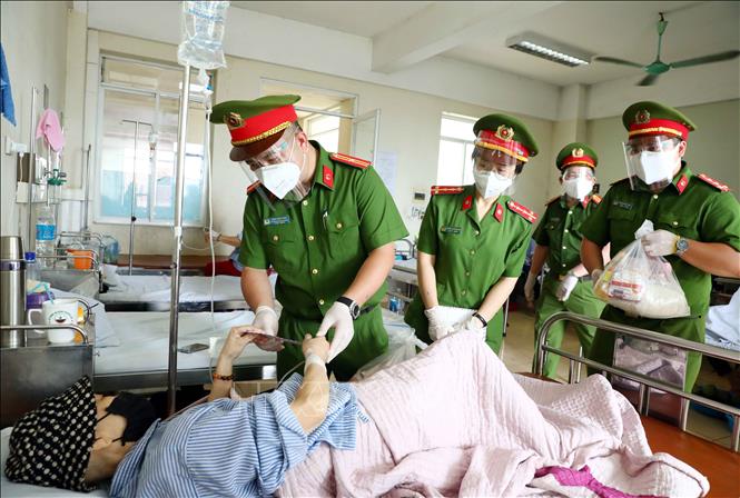 Trong ảnh: Cán bộ, chiến sỹ Công an phường Mai Dịch (quận Cầu Giấy, Hà Nội) trao quà hỗ trợ cho bệnh nhân có hoàn cảnh khó khăn đang điều trị tại trung tâm Ung Bướu, bệnh viện 19 - 8 Bộ Công an. Ảnh: Phạm Kiên - TTXVN