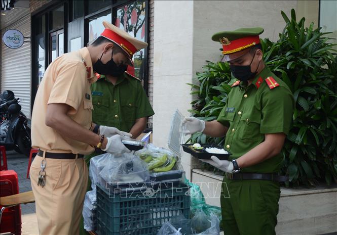 Trong ảnh: Chiến sĩ công an thành phố Đà Nẵng kiểm tra các suất cơm trước khi chuyển vào cho người dân cách ly tại khách sạn Vanda do hai hành khách người Anh lưu trú tại khách sạn có xét nghiệm dương tính với virus SARS-CoV-2. Ảnh: Văn Dũng – TTXVN