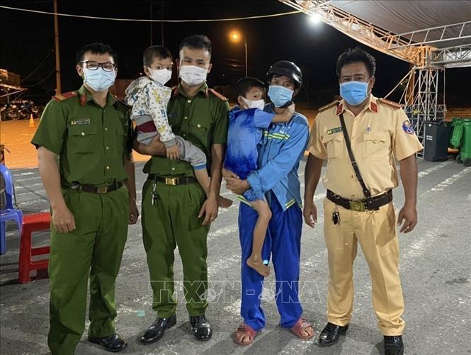 Khoảng 2 giờ sáng 28/7/2021, khi đang làm nhiệm vụ tại chốt kiểm soát dịch COVID-19 trên đường Võ Nguyên Giáp thuộc địa bàn phường Tân Phú, quận Cái Răng, thành phố Cần Thơ, cán bộ trực chốt nhận được thông tin từ các tài xế xe ô tô là có hai bé trai đang đi bộ từ hướng Hậu Giang lên Cần Thơ, có biểu hiện hoảng loạn. Tổ kiểm soát nhanh chóng đi tìm và đưa hai bé về chốt, cho các bé ăn uống, ổn định tinh thần, liên hệ với người nhà đến đón về an toàn. Ảnh: TTXVN phát