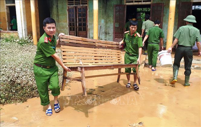 Trong ảnh : Các chiến sỹ công an huyện Hương Khê (Hà Tĩnh) chung tay dọn vệ sinh môi trường sau lũ tại xã Hương Đô. Ảnh: Phan Quân - TTXVN