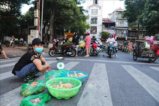 Từ sáng sớm 16/8, hàng chục tiểu thương cùng người đi chợ tràn xuống lòng đường khu vực bốt Hàng Đậu, bất chấp quy định phòng chống dịch (Ảnh chụp lúc 6h sáng). Ảnh: Thành Đạt - TTXVN