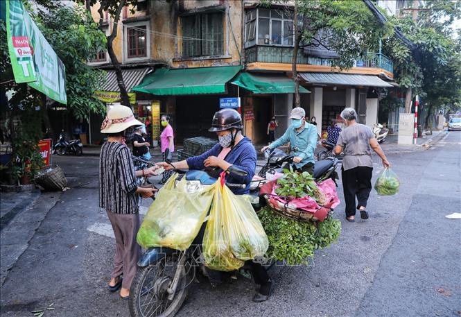 Các tiểu thương và người mua tiếp tục di chuyển xuống đoạn ngã ba Hàng Đậu - Nguyễn Thiệp để mua bán sau khi việc họp chợ khu vực bốt Hàng Đậu bị lực lượng chức năng giải tán. Ảnh: Thành Đạt - TTXVN