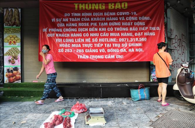 Một tiểu thương ngang nhiên bày thịt ra bán giữa lòng đường phố Hàng Đường (Ảnh chụp 6h30 sáng 16/8). Ảnh: Thành Đạt - TTXVN 