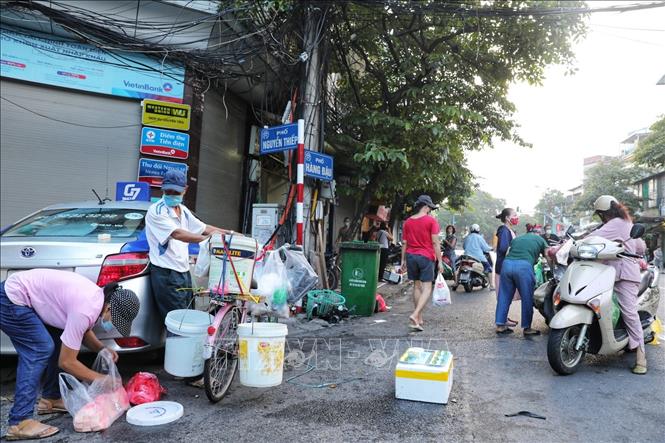 Các tiểu thương và người mua tiếp tục di chuyển xuống đoạn ngã ba Hàng Đậu - Nguyễn Thiệp để mua bán sau khi việc họp chợ khu vực bốt Hàng Đậu bị lực lượng chức năng giải tán. Ảnh: Thành Đạt - TTXVN