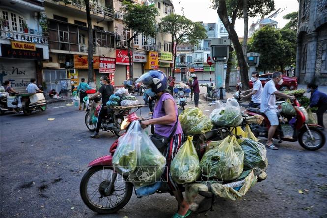 Tiểu thương và người đi chợ ngang nhiên tràn ra đường họp chợ như chưa hề có dịch bệnh, tại mặt đường Quán Thánh, khu vực bốt Hàng Đậu (ảnh chụp lúc 5h30 sáng 16/8). Ảnh: Thành Đạt - TTXVN