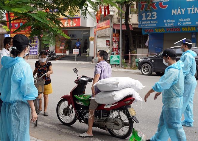 Trong ảnh: Đại diện các hộ dân sống trong “ngõ chạy thận” Lê Thanh Nghị, quận Hai Bà trưng nhận quà hỗ trợ từ hội thiện nguyện Hà Nội. Ảnh: Tuấn Anh – TTXVN