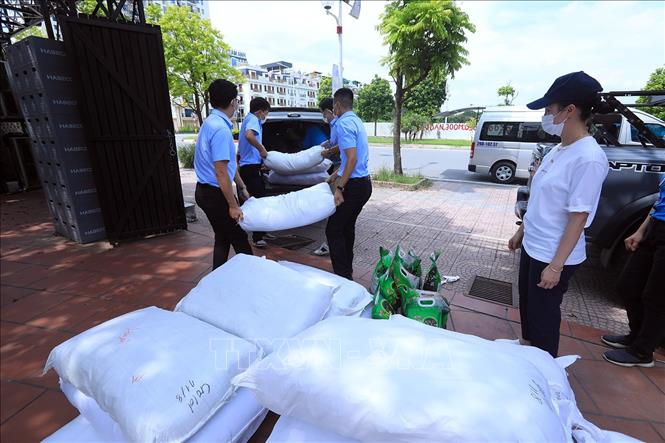 Trong ảnh: Cán bộ Công ty TNHH Một thành viên Môi trường Đô thị Hà Nội (URENCO) chuyển các bao gạo lên xe để chở đến các điểm trao tặng cho công nhân của công ty. Ảnh: Tuấn Anh – TTXVN