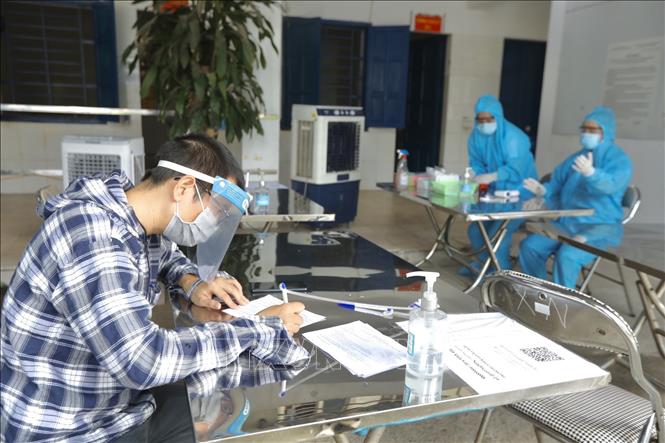 Trong ảnh: Người dân bắt buộc phải khai báo y tế, kiểm tra thân nhiệt trước khi vào Bệnh viện đa khoa Thanh Trì. Ảnh: Minh Quyết - TTXVN
