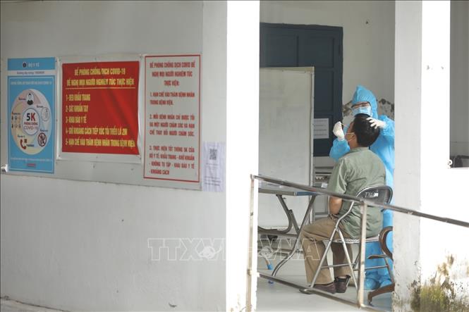 Trong ảnh: Người có biểu hiện liên quan đến COVID-19 được khám sàng lọc theo phòng riêng và lấy mẫu test nhanh COVID-19 để phân luồng theo quy định. Ảnh: Minh Quyết - TTXVN