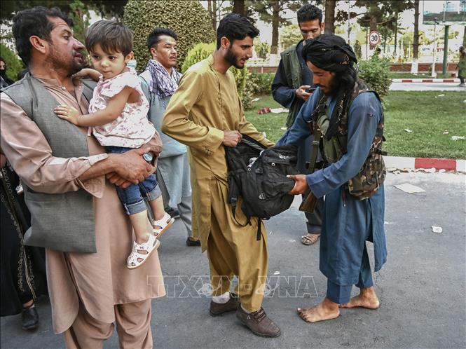 Trong ảnh: Một tay súng Taliban kiểm tra hành lý của người dân tại khu vực sân bay  Kabul, Afghanistan ngày 16/8/2021. Ảnh: AFP/TTXVN