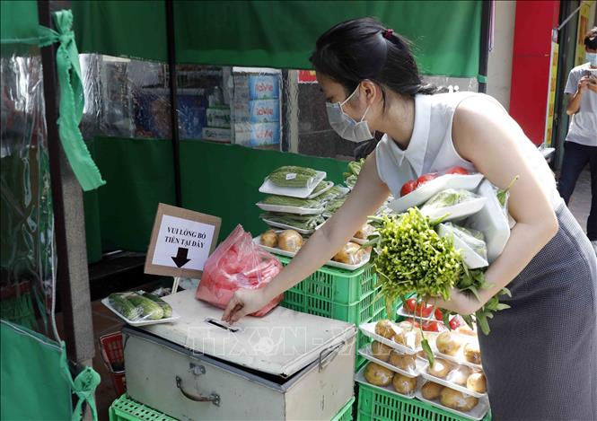 Trong ảnh: Khách lựa chọn tại cửa hàng không người bán tại phố Đại Linh, phường Trung Văn, quận Nam Từ Liêm. Ảnh: Trần Việt - TTXVN