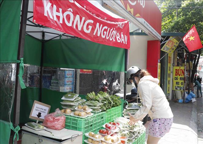 Trong ảnh: Khách lựa chọn tại cửa hàng không người bán tại phố Đại Linh, phường Trung Văn, quận Nam Từ Liêm. Ảnh: Trần Việt - TTXVN