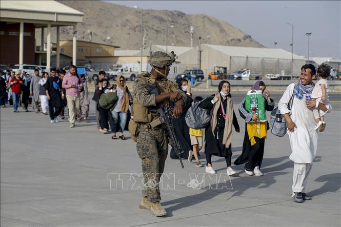 Trong ảnh: Dòng người xếp hàng lên máy bay sơ tán tại sân bay Hamid Karzai ở Kabul, Afghanistan ngày 18/8/2021. Ảnh: AFP/TTXVN