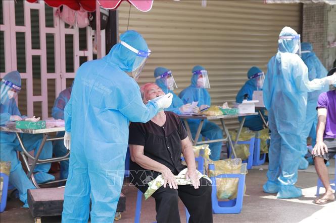 Photo: Health workers take samples for rapid COVID-19 testing for people at Thuan An city and Tan Uyen township in Binh Duong province, one of the COVID hot spots in the south. VNA Photo: Chí Tưởng