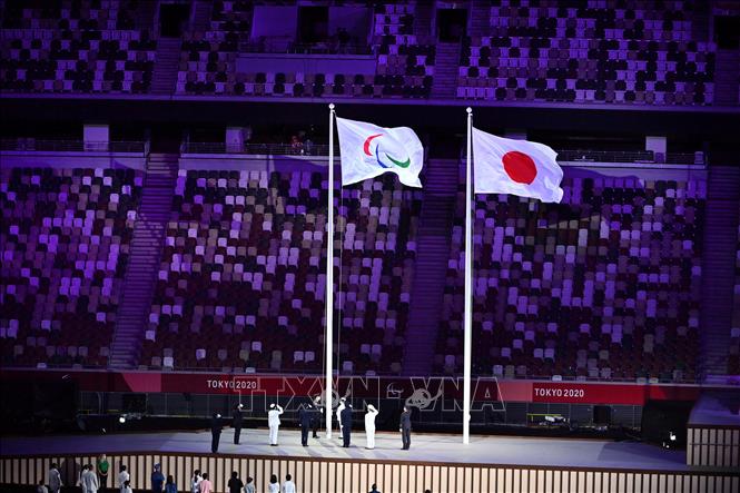 Trong ảnh: Lễ thượng cờ Paralympic (trái) tại lễ khai mạc Paralympic Tokyo 2020 ở Tokyo, Nhật Bản, ngày 24/8/2021. Ảnh: AFP/ TTXVN