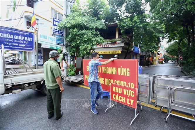 Trong ảnh: Sáng 26/8/2021, lực lượng chức năng rào tạm ngõ 24 Kim Đồng trước khi rào chắn cứng. Ảnh: Hoàng Hiếu - TTXVN 