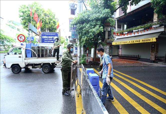 Trong ảnh: Sáng 26/8/2021, lực lượng chức năng rào tạm ngõ 24 Kim Đồng trước khi rào chắn cứng. Ảnh: Hoàng Hiếu - TTXVN 
