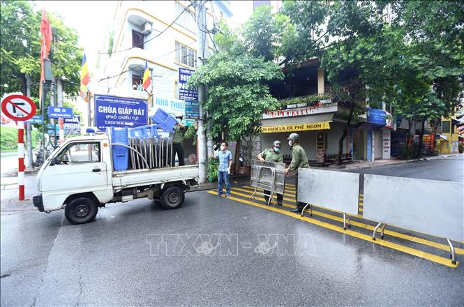 Trong ảnh: Sáng 26/8/2021, lực lượng chức năng rào tạm ngõ 24 Kim Đồng trước khi rào chắn cứng. Ảnh: Hoàng Hiếu - TTXVN 