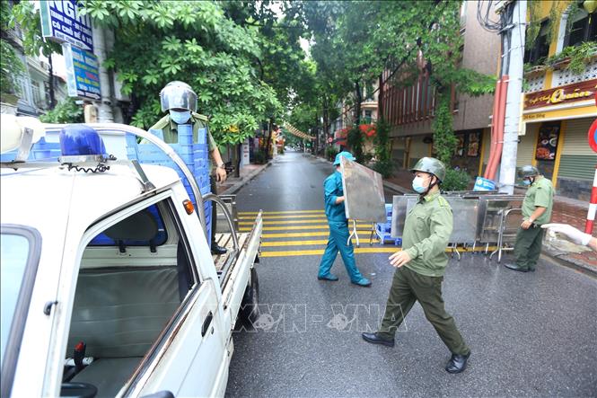 Trong ảnh: Sáng 26/8/2021, lực lượng chức năng rào tạm ngõ 24 Kim Đồng trước khi rào chắn cứng. Ảnh: Hoàng Hiếu - TTXVN 