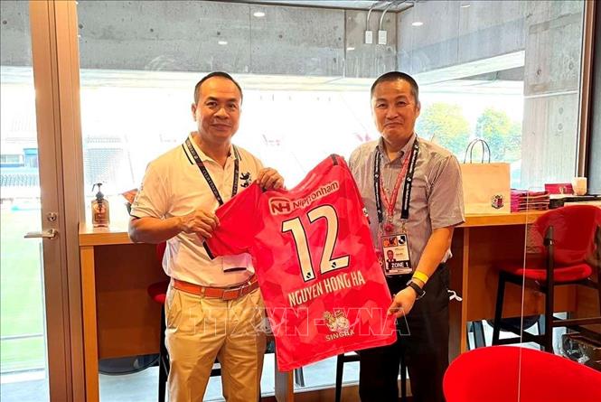 Tổng Lãnh sự Việt Nam tại Osaka Nguyễn Hồng Hà (trái) được tặng áo đấu của CLB Cerezo Osaka. Ảnh: TTXVN phát