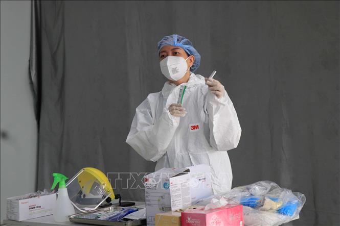 Trong anh: Hướng dẫn tình nguyện viên của Công ty TNHH GoerTek Vina (khu công nghiệp Quế Võ, tỉnh Bắc Ninh) lấy mẫu xét nghiệm. Ảnh: Thanh Thương- TTXVN