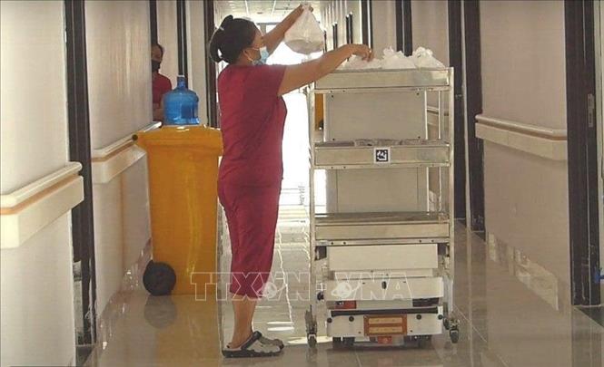 Trong ảnh: Robot VIBOT-2 giúp vận chuyển đồ ăn đến từng phòng phục vụ bệnh nhân nhiễm COVID-19, hạn chế được việc tiếp xúc gần, giảm nguy cơ lây nhiễm cho các nhân viên y tế. Ảnh: TTXVN phát 