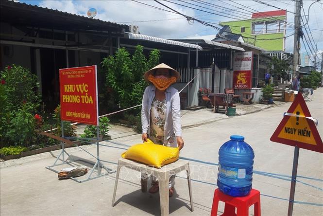 Trong ảnh: Gần 100 hộ dân tại khu vực phong tỏa tại khóm 4 và khóm 8, phường 8, thành phố Cà Mau được hỗ trợ gạo và các nhu yếu phẩm cần thiết trong thời gian thực hiện cách ly y tế để phòng, chống dịch COVID-19. Ảnh: Kim Há-TTXVN