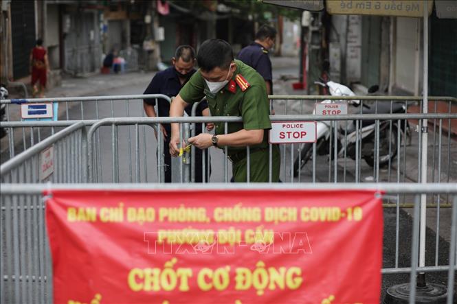Trong ảnh: Lực lượng công an phường Đội Cấn lập hàng rào cứng tại 2 đầu chợ Ngọc Hà, đảm bảo công tác phòng chống dịch. Ảnh: Thành Đạt - TTXVN
