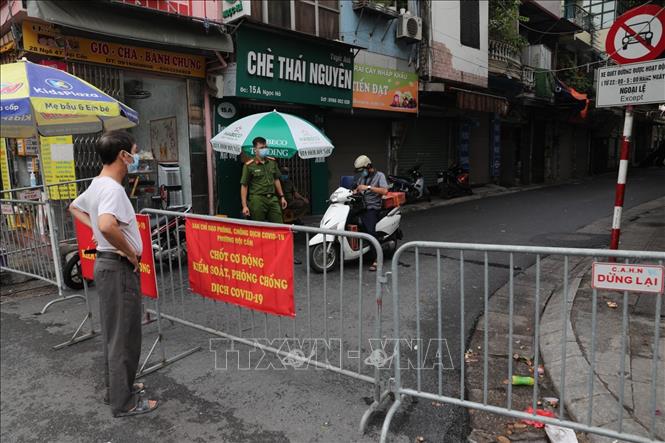 Trong ảnh: Lực lượng chức năng phường Đội Cấn yêu cầu người dân tạm thời không di chuyển khỏi khu vực chợ. Ảnh: Thành Đạt - TTXVN