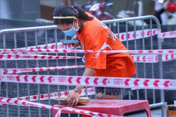 Trong ảnh: Người dân tại chung cư 210B Lê Trọng Tấn, phường Khương Mai (quận Thanh Xuân) nhận nhu yếu phẩm. Ảnh: Tuấn Đức - TTXVN 