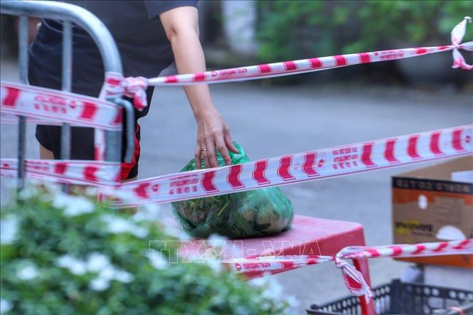 Trong ảnh: Người dân tại chung cư 210B Lê Trọng Tấn, phường Khương Mai (quận Thanh Xuân) nhận nhu yếu phẩm. Ảnh: Tuấn Đức - TTXVN