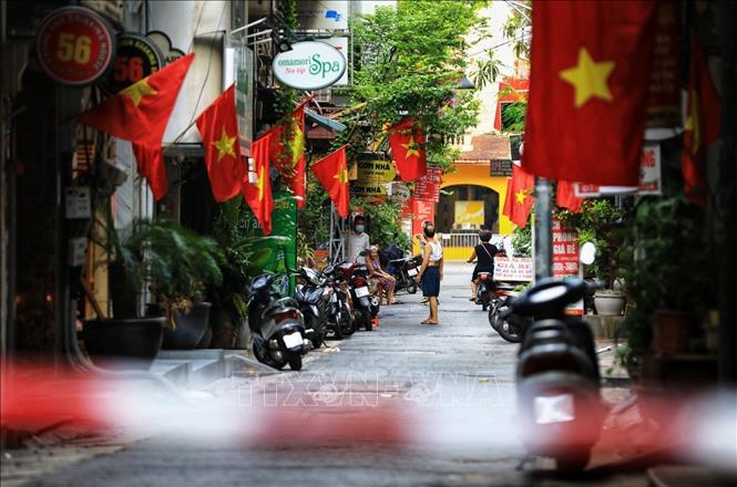 Mặc dù vẫn đang trong giai đoạn thực hiện giãn cách xã hội phòng, chống dịch COVID-19 nhưng ở khắp phố phường, ngõ xóm, người Hà Nội vẫn trang trọng cắm lá cờ Tổ quốc. Trong ảnh: Bên trong 