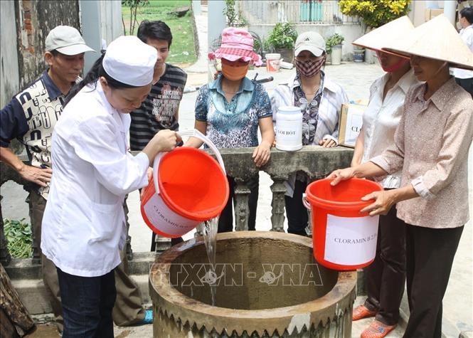 Lĩnh vực y tế phát triển mạnh mẽ, đạt nhiều thành tựu.Trong ảnh: Cán bộ y tế xã Đức Long hướng dẫn người dân khử trùng nguồn nước sinh hoạt trước mùa mưa bão. Ảnh: Dương Ngọc - TTXVN