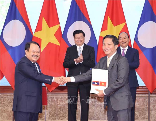 Thủ tướng Nguyễn Xuân Phúc và Thủ tướng Lào Thongloun Sisoulith chứng kiến lễ ký các văn kiện hợp tác giữa hai nước tại Kỳ họp lần thứ 43 Uỷ ban liên Chính phủ Việt - Lào về hợp tác song phương (6/12/2020). Ảnh: Thống Nhất – TTXVN