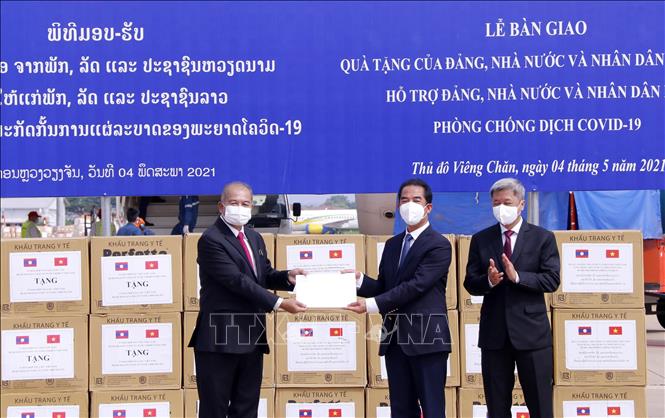 Phó Thủ tướng, Chủ tịch Uỷ ban chuyên trách Trung ương về phòng chống COVID-19 của Lào Kikeo Khaykhamphithoune (phải) trao thư cảm ơn của Đảng, Nhà nước và nhân dân Lào gửi Đảng, Nhà nước và nhân dân Việt Nam tại Lễ trao tặng quà Việt Nam hỗ trợ Lào ứng phó dịch COVID-19. Ảnh: Phạm Kiên - Pv TTXVN tại Lào