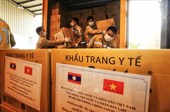  Nhân viên cảng vụ hàng không Nội Bài vận chuyển những thùng hàng vật tư, thiết bị y tế lên máy bay chuyển sang giúp nhân dân Lào. Đây là quà tặng của Đảng, Nhà nước và nhân dân Việt Nam hỗ trợ Đảng, Nhà nước và nhân dân Lào ứng phó dịch COVID-19 (4/5/2021). Ảnh: Thành Đạt - TTXVN