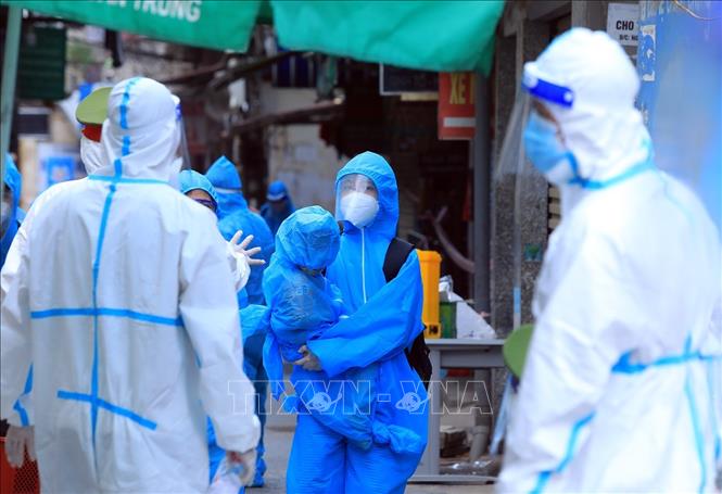 Trong ảnh: Hai mẹ con sống tại ngõ 328 Nguyễn Trãi di chuyển đến khu cách ly. Ảnh: Tuấn Anh - TTXVN