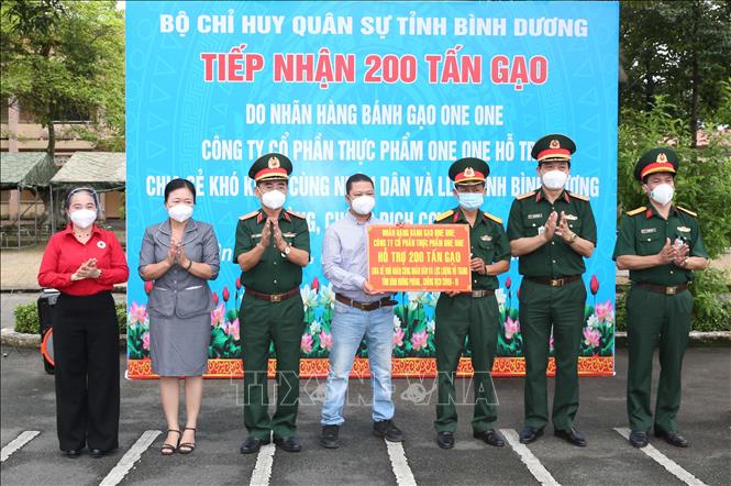 Trong ảnh: Đại diện Lãnh đạo Nhãn hàng Bánh gạo One One trao biểu trưng 200 tấn gạo. Ảnh: Hồng Pha - TTXVN phát
