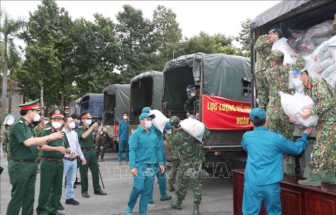Trong ảnh: Lực lượng quân đội và dân quân tự vệ tiếp nhận gạo hỗ trợ. Ảnh: Hồng Pha - TTXVN phát