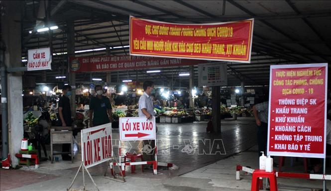 Người vào chợ Đông Thành, thành phố Thanh Hóa mua hàng phải có phiếu đị chợ. Ảnh: Nguyễn Nam-TTXVN