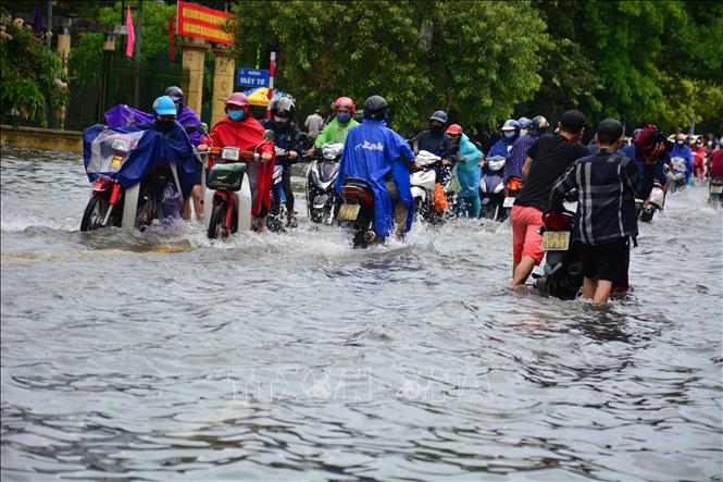 Trong ảnh: Các phương tiện lưu thông qua chân cầu Đò Quan gặp khó khăn do nước ngập sâu. Ảnh: Công Luật - TTXVN
