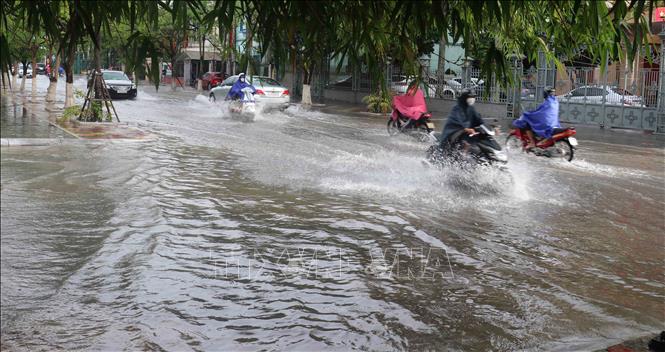 Trong ảnh: Mưa to gây ngập tại nhiều đoạn đường trong thành phố, khiến người và phương tiện gặp nhiều khó khăn khi tham gia giao thông. Ảnh: Nguyễn Công Hải-TTXVN
