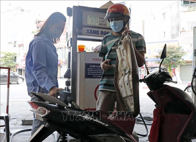 Trong ảnh: Mua bán xăng dầu sau khi tăng giá. Ảnh: Trần Việt - TTXVN