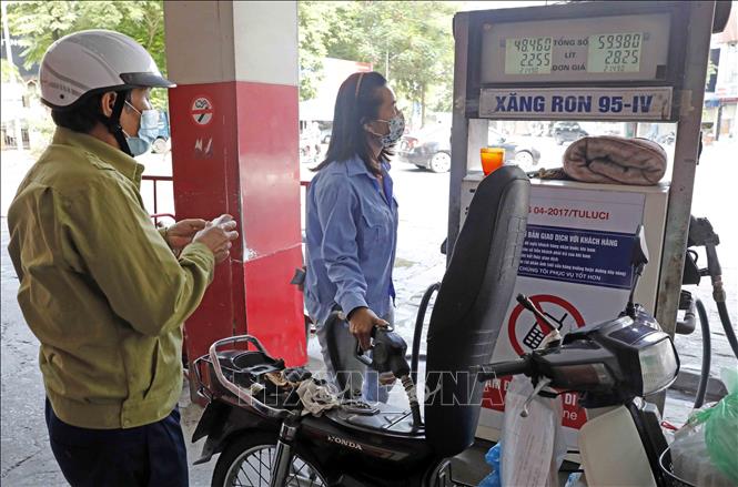 Trong ảnh: Mua bán xăng dầu sau khi tăng giá. Ảnh: Trần Việt - TTXVN