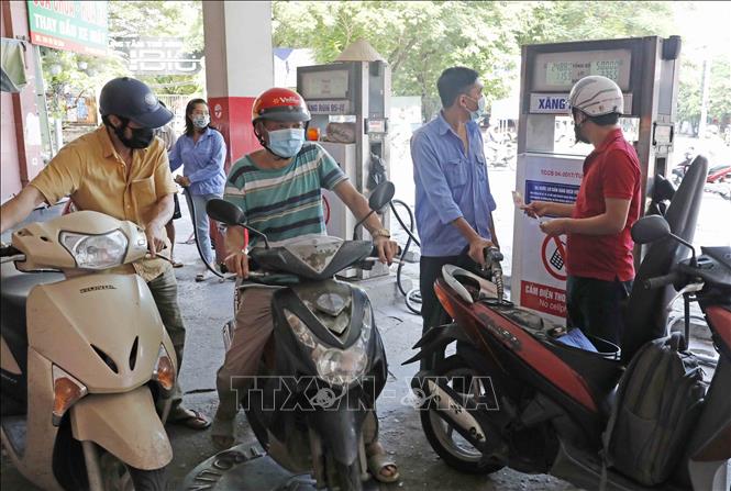 Trong ảnh: Mua bán xăng dầu sau khi tăng giá. Ảnh: Trần Việt - TTXVN