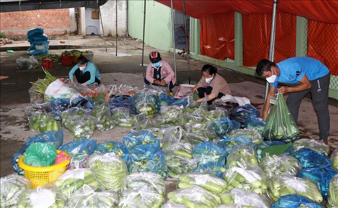 Trong ảnh: Các đoàn thể thị trấn Vàm Láng chuẩn bị rau củ quả hỗ trợ người dân trong khu vực phong tỏa. Ảnh: Hữu Chí – TTXVN