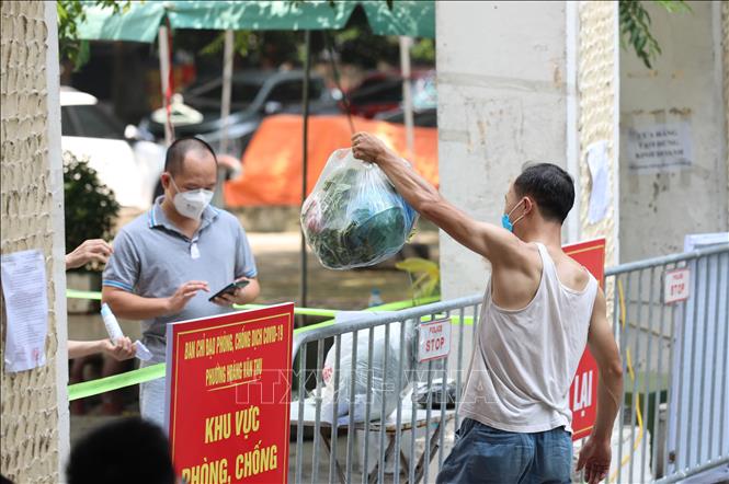 Trong ảnh: Người dân tới chuyển đồ cho người thân trong khu vực phong tỏa. Ảnh: Thanh Tùng - TTXVN