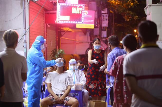 Trong ảnh: Nhân viên y tế lấy mẫu xét nghiệm cho người dân phường Vĩnh Tuy (quận Hai Bà Trưng) tại điểm lấy mẫu 461 phố Minh Khai. Ảnh: Hoàng Hiếu - TTXVN